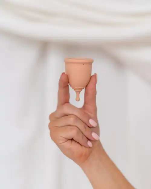 Menstruatiecup in beige-roze kleur, vooraanzicht
